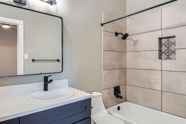 bathroom with toilet, a textured wall, vanity, and shower / bathing tub combination