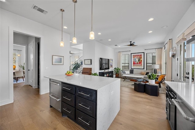 kitchen with ceiling fan, dark cabinets, visible vents, a warming drawer, and light wood finished floors