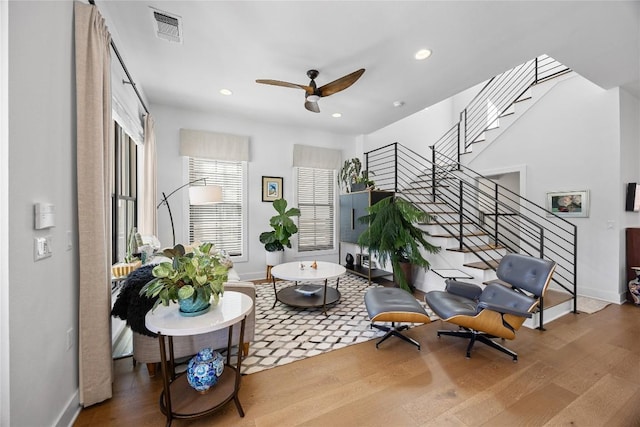 living area with stairway, wood finished floors, visible vents, and recessed lighting