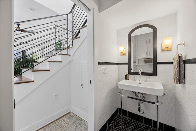 bathroom with a sink, tile walls, and wainscoting