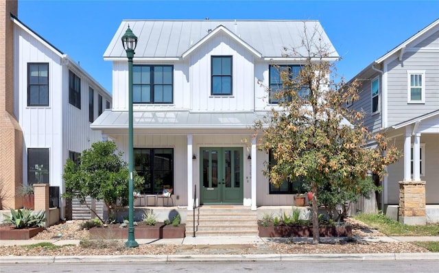 modern farmhouse style home featuring french doors, a porch, board and batten siding, a standing seam roof, and metal roof