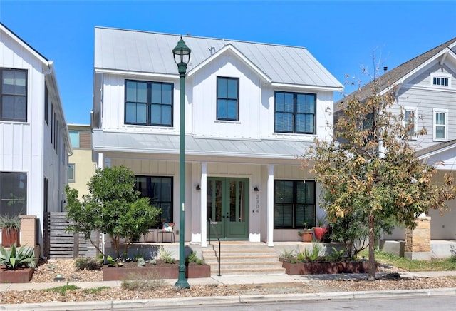 modern farmhouse featuring french doors, a porch, board and batten siding, a standing seam roof, and metal roof