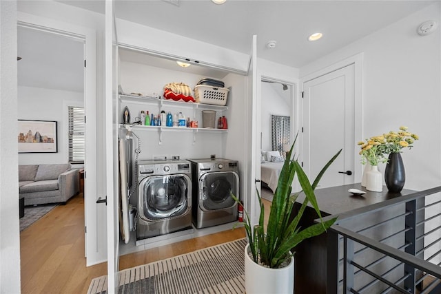 laundry area featuring laundry area, washer and clothes dryer, wood finished floors, and recessed lighting