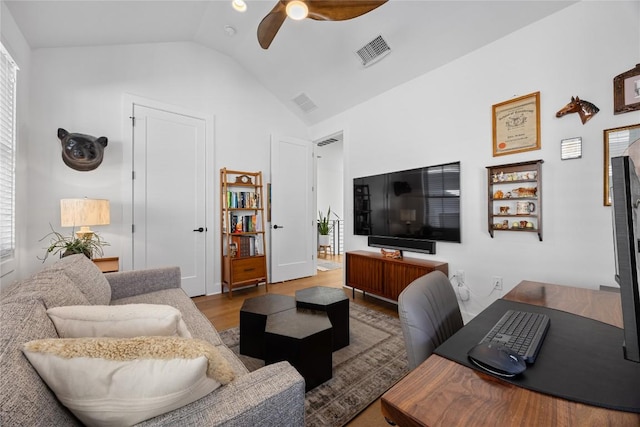 living room with lofted ceiling, ceiling fan, visible vents, and wood finished floors