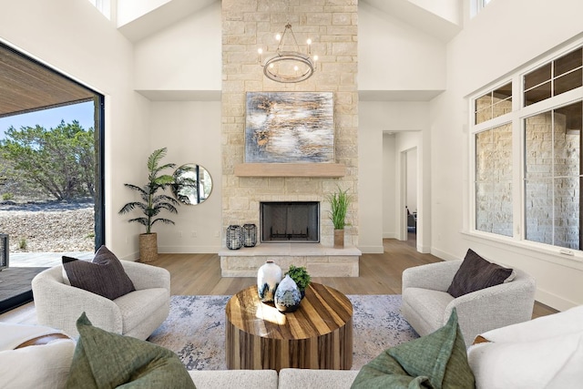 living room with baseboards, a fireplace, high vaulted ceiling, and wood finished floors