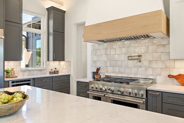 kitchen with gray cabinetry, stainless steel appliances, and custom range hood