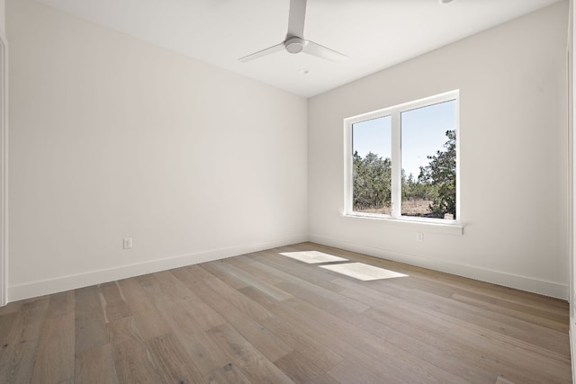 unfurnished room featuring ceiling fan, wood finished floors, and baseboards