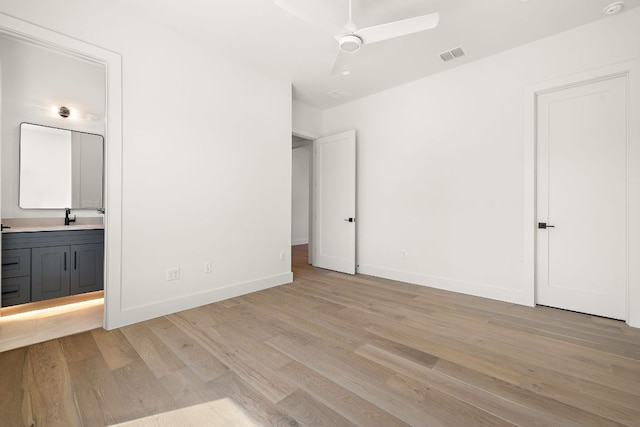 unfurnished bedroom with light wood-type flooring, ensuite bath, visible vents, and baseboards