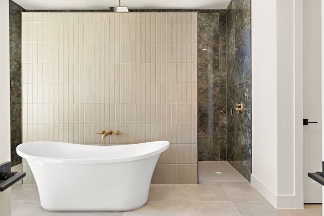 bathroom featuring a freestanding tub, tile patterned flooring, a walk in shower, and tile walls