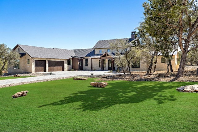 view of front of house featuring a garage, a chimney, metal roof, a standing seam roof, and a front yard