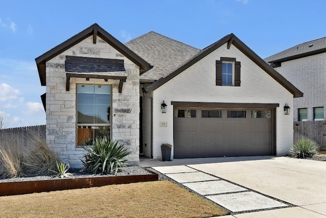 view of front of home with stone siding, brick siding, driveway, and roof with shingles