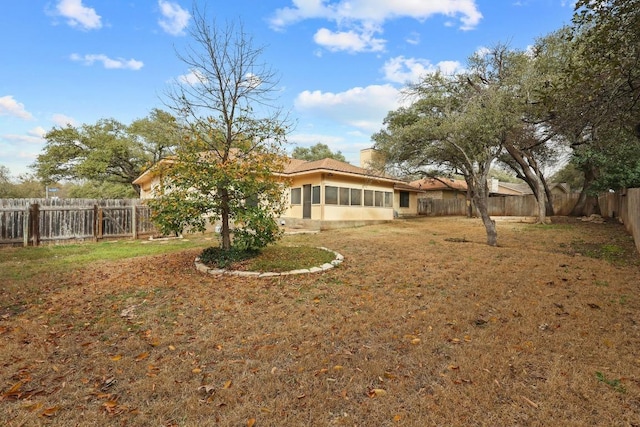 view of yard with a sunroom and a fenced backyard