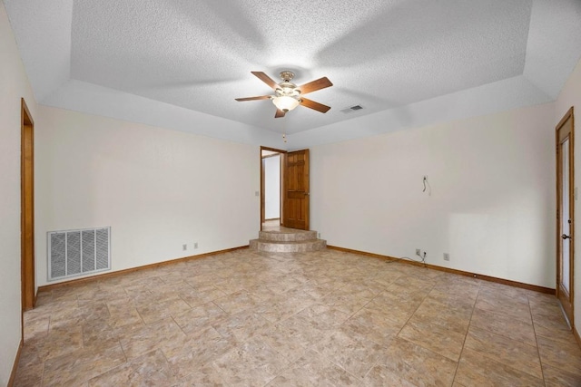 spare room with baseboards, visible vents, and a ceiling fan