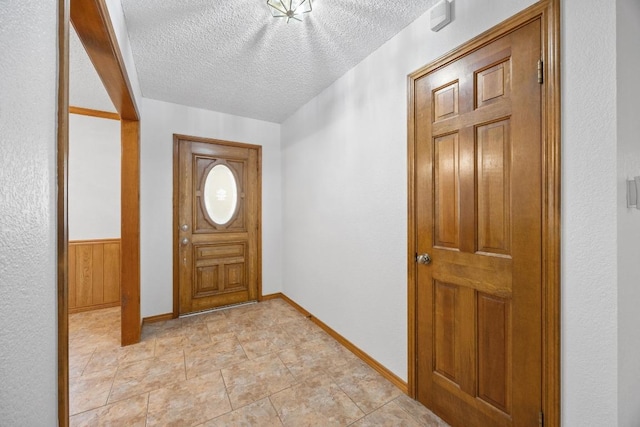 entryway with a textured ceiling and baseboards