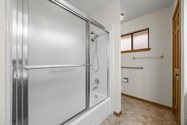 bathroom with bath / shower combo with glass door, toilet, a textured ceiling, baseboards, and tile patterned floors