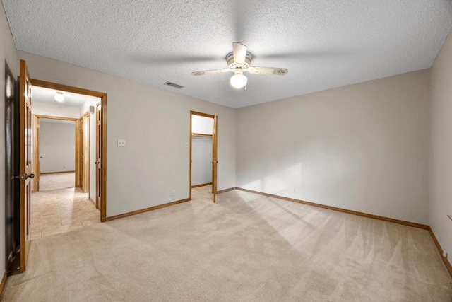 unfurnished room with baseboards, visible vents, a ceiling fan, and light colored carpet