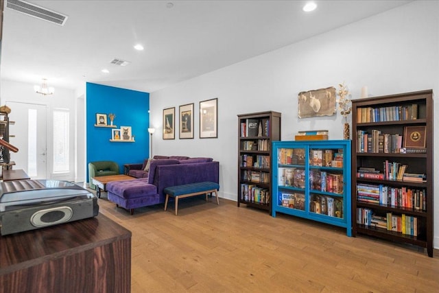 living area featuring recessed lighting, visible vents, and wood finished floors