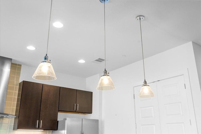 room details with decorative light fixtures, recessed lighting, visible vents, dark brown cabinets, and fridge