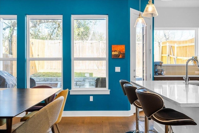 dining space with a healthy amount of sunlight, baseboards, and wood finished floors