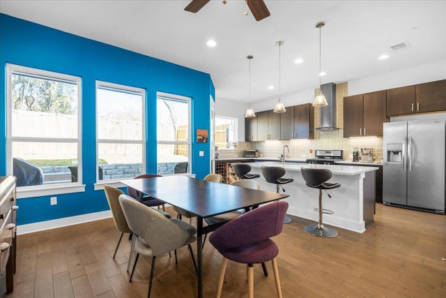 dining space featuring ceiling fan, baseboards, wood finished floors, and recessed lighting