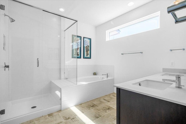 bathroom featuring a garden tub, a shower stall, a sink, and recessed lighting