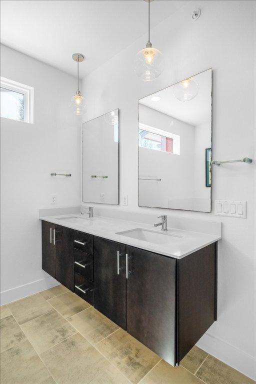 full bath with a wealth of natural light, a sink, and double vanity