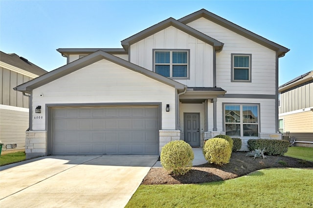 craftsman-style home featuring driveway, stone siding, board and batten siding, and an attached garage