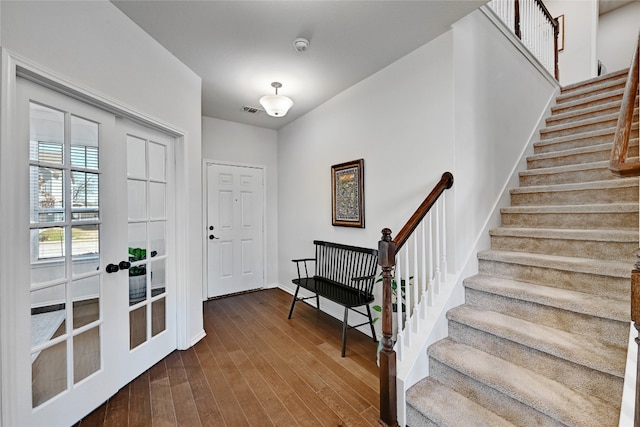 foyer entrance with stairs, french doors, dark wood finished floors, and visible vents