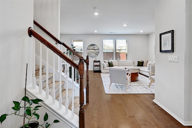 living room featuring stairs, hardwood / wood-style floors, recessed lighting, and baseboards