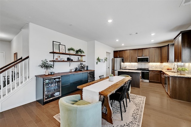 dining area featuring beverage cooler, visible vents, and light wood-style floors