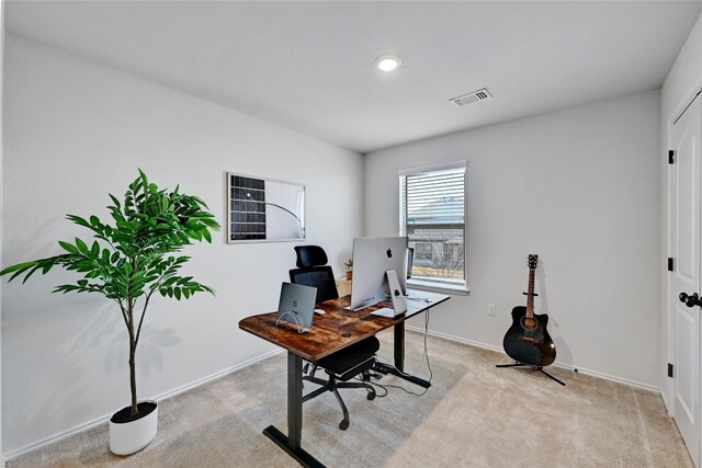 office area with baseboards, visible vents, and light colored carpet