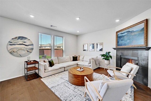 living area with a fireplace, wood finished floors, visible vents, and recessed lighting