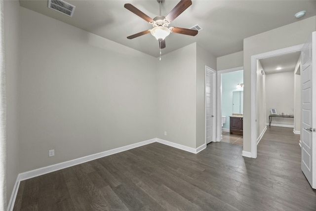 unfurnished room with ceiling fan, dark wood finished floors, visible vents, and baseboards