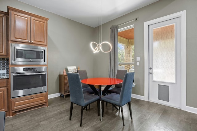 dining room with baseboards, dark wood-type flooring, and a notable chandelier