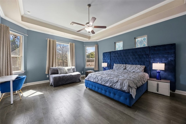 bedroom featuring a tray ceiling, multiple windows, wood finished floors, and baseboards