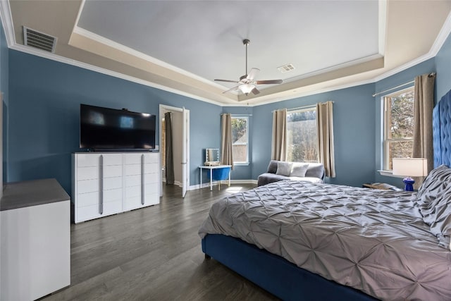 bedroom featuring wood finished floors, a raised ceiling, visible vents, and baseboards