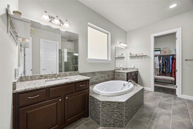 full bath with a bath, a shower stall, a sink, and tile patterned floors