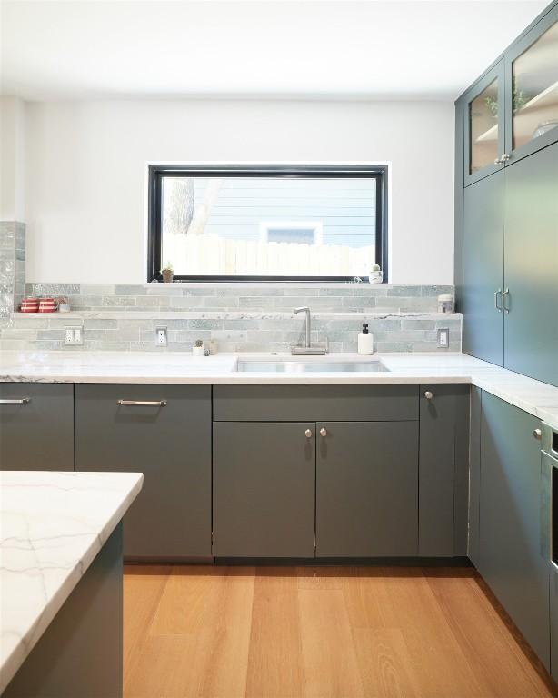 2703 Pegram Ave, Austin, TX 78757 - bathroom featuring a sink, wood finished floors, and backsplash