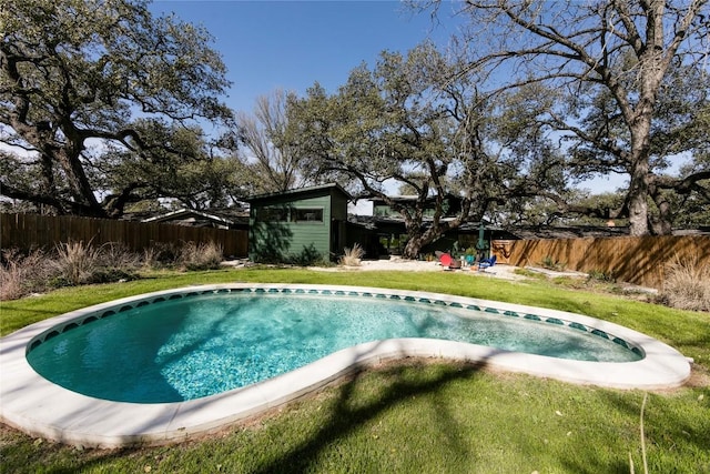 view of swimming pool with a fenced in pool, a lawn, a fenced backyard, a storage unit, and an outdoor structure