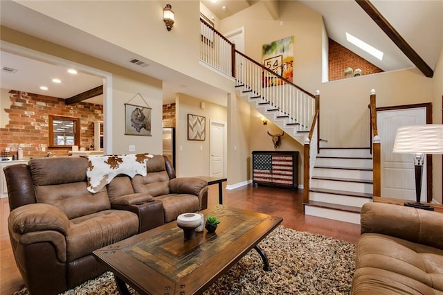 living area with beam ceiling, wood finished floors, high vaulted ceiling, baseboards, and stairs