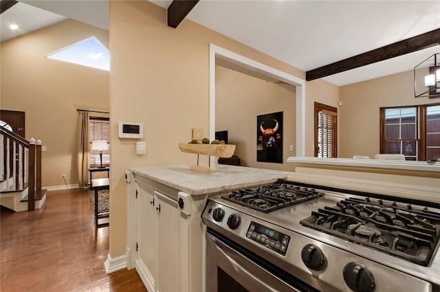 kitchen with plenty of natural light, beam ceiling, and gas stove