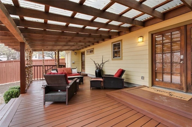 wooden deck with an outdoor hangout area, fence, and a pergola