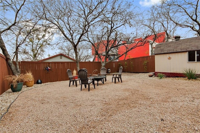 view of yard featuring a fenced backyard and a fire pit