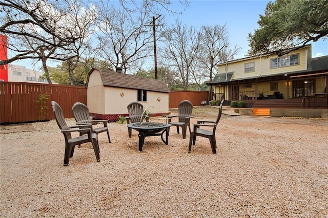 view of yard with a storage shed, an outdoor fire pit, an outdoor structure, and a fenced backyard