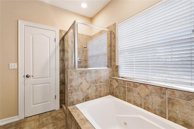 bathroom with a wealth of natural light, tile patterned flooring, a garden tub, and a tile shower