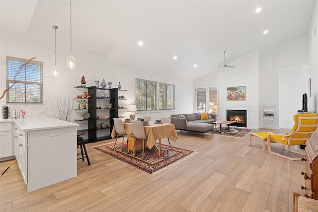 dining space with light wood-type flooring, a fireplace, and recessed lighting