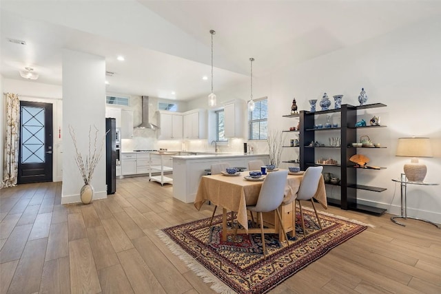 dining area with lofted ceiling, recessed lighting, baseboards, and light wood-style floors