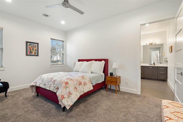 bedroom with baseboards, visible vents, carpet flooring, and ensuite bathroom