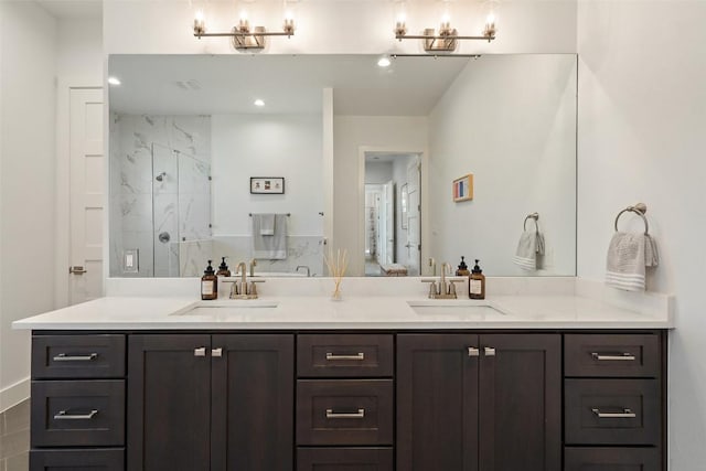 full bath featuring double vanity, a sink, a marble finish shower, and recessed lighting