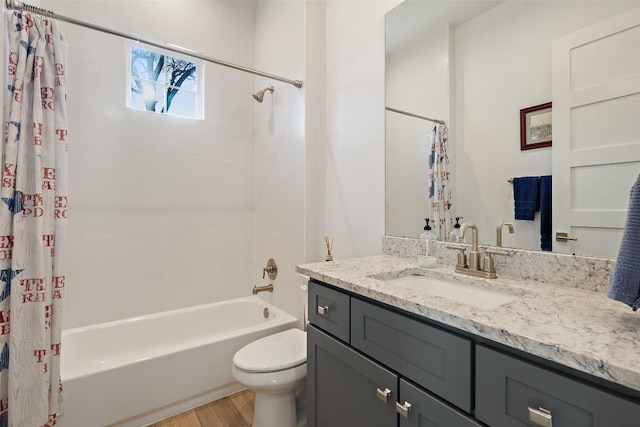 full bath featuring wood finished floors, shower / bathtub combination with curtain, toilet, and vanity